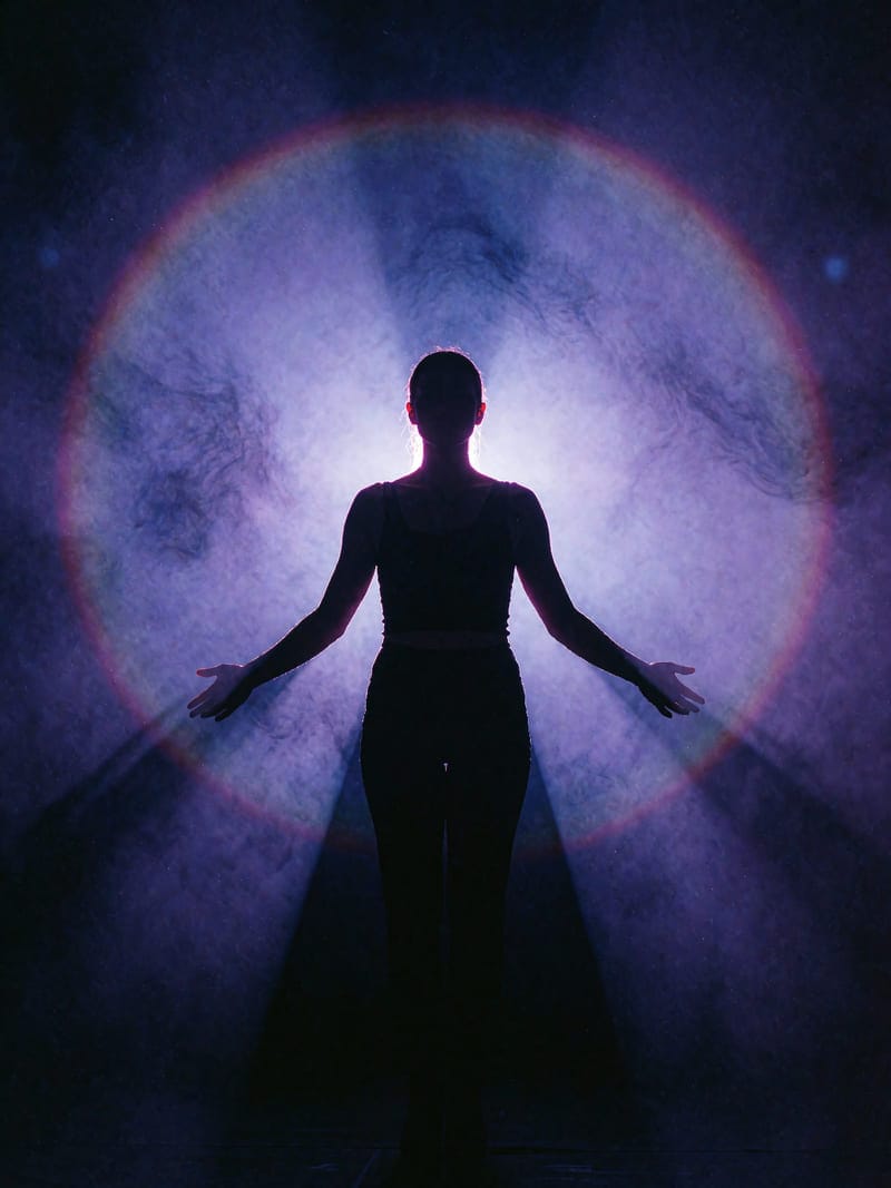 A stage performer backlit in violet